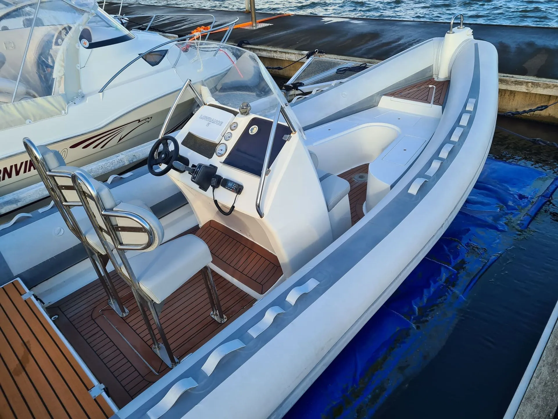 Fiberglass speedboat with white hull and console docked alongside other vessels in Jacksonville marina.