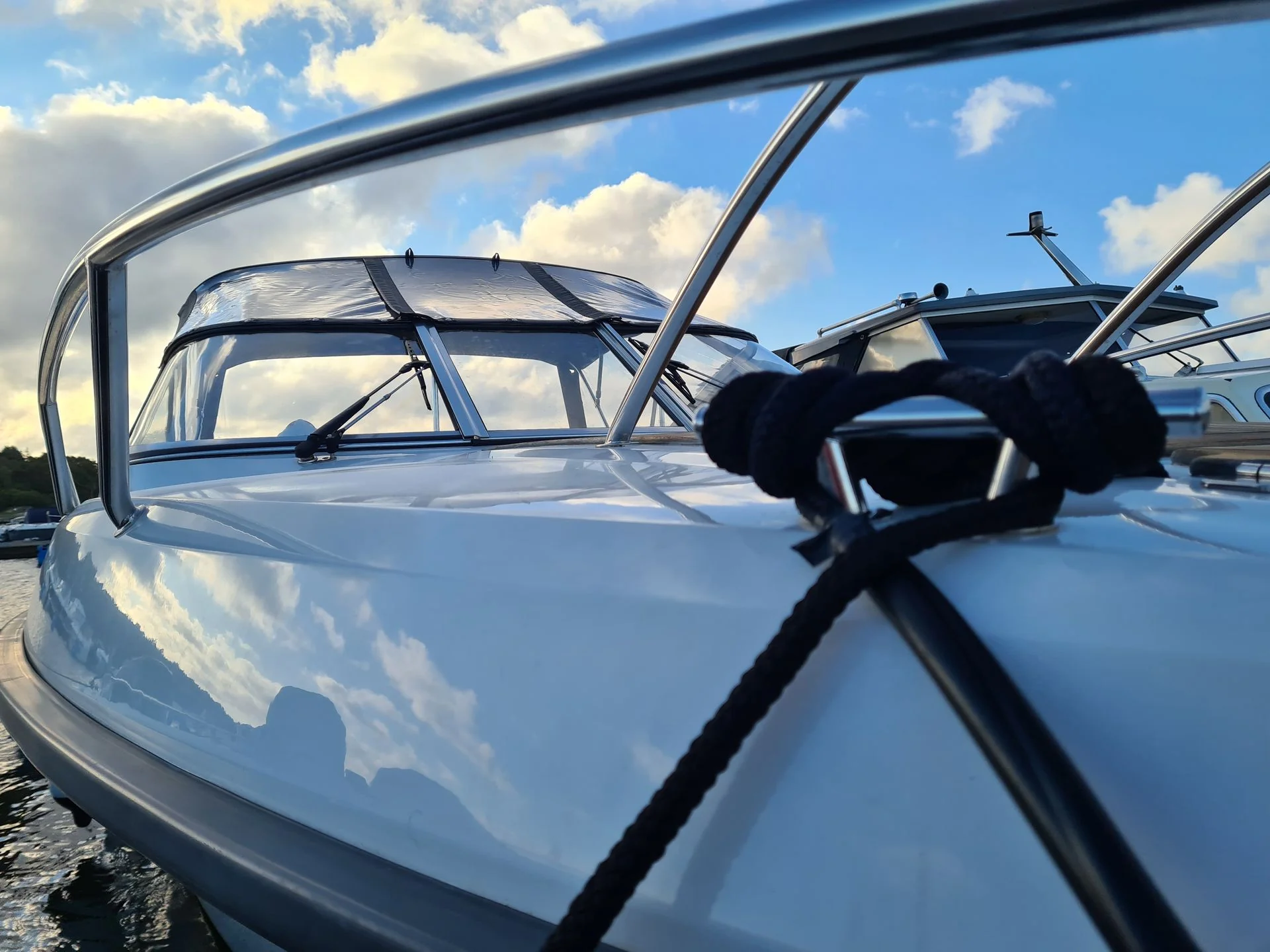 Multiple fiberglass boats moored at dock with open windshields and cleats visible under bright Florida sky.