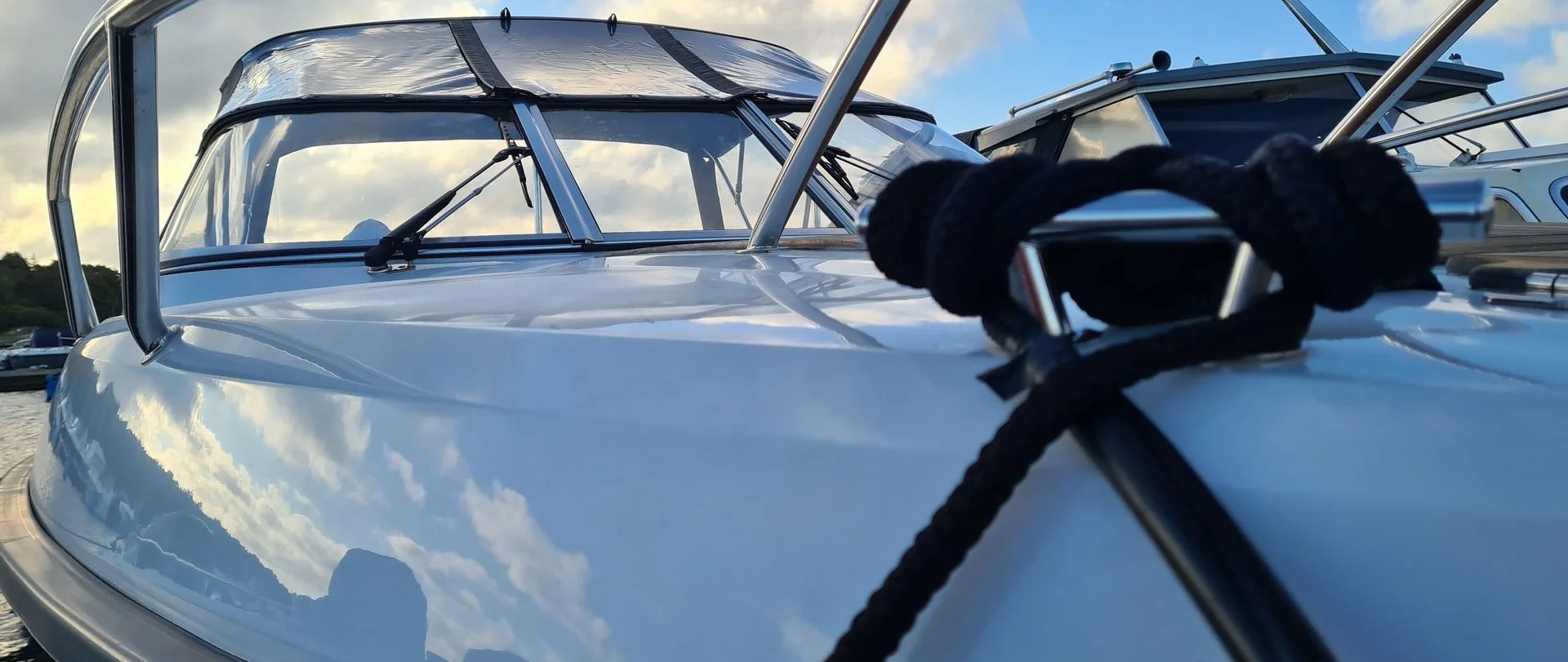 Fiberglass boat hull detail with wake tower and cleats in bright daylight.