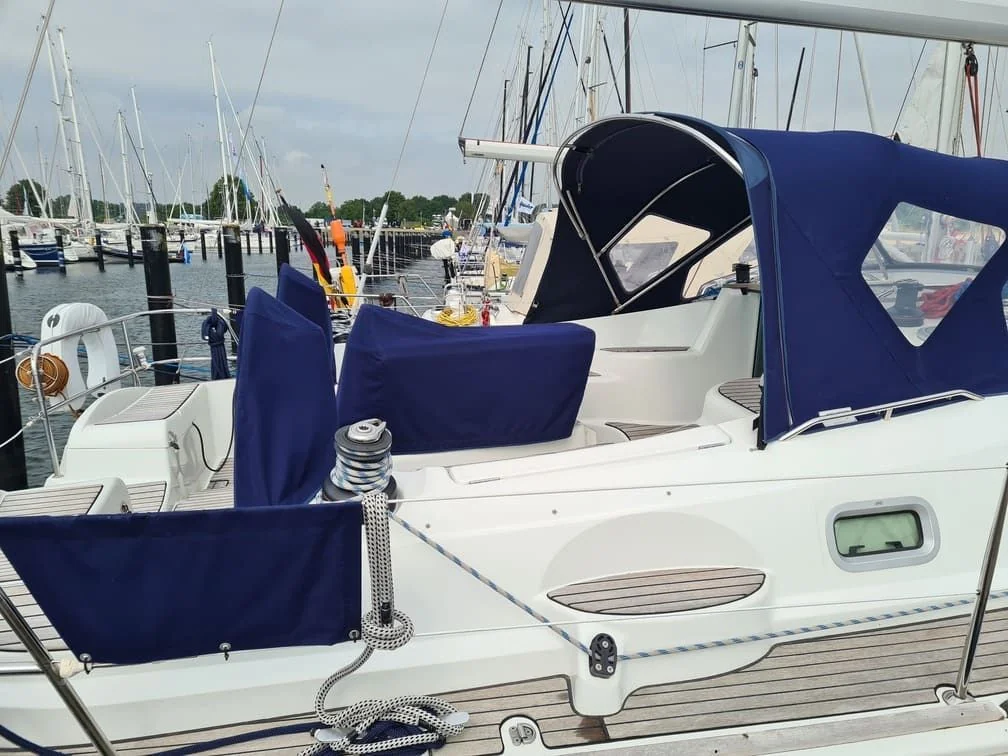 Sailboat moored at Jacksonville marina with canvas canopy and rigging visible.