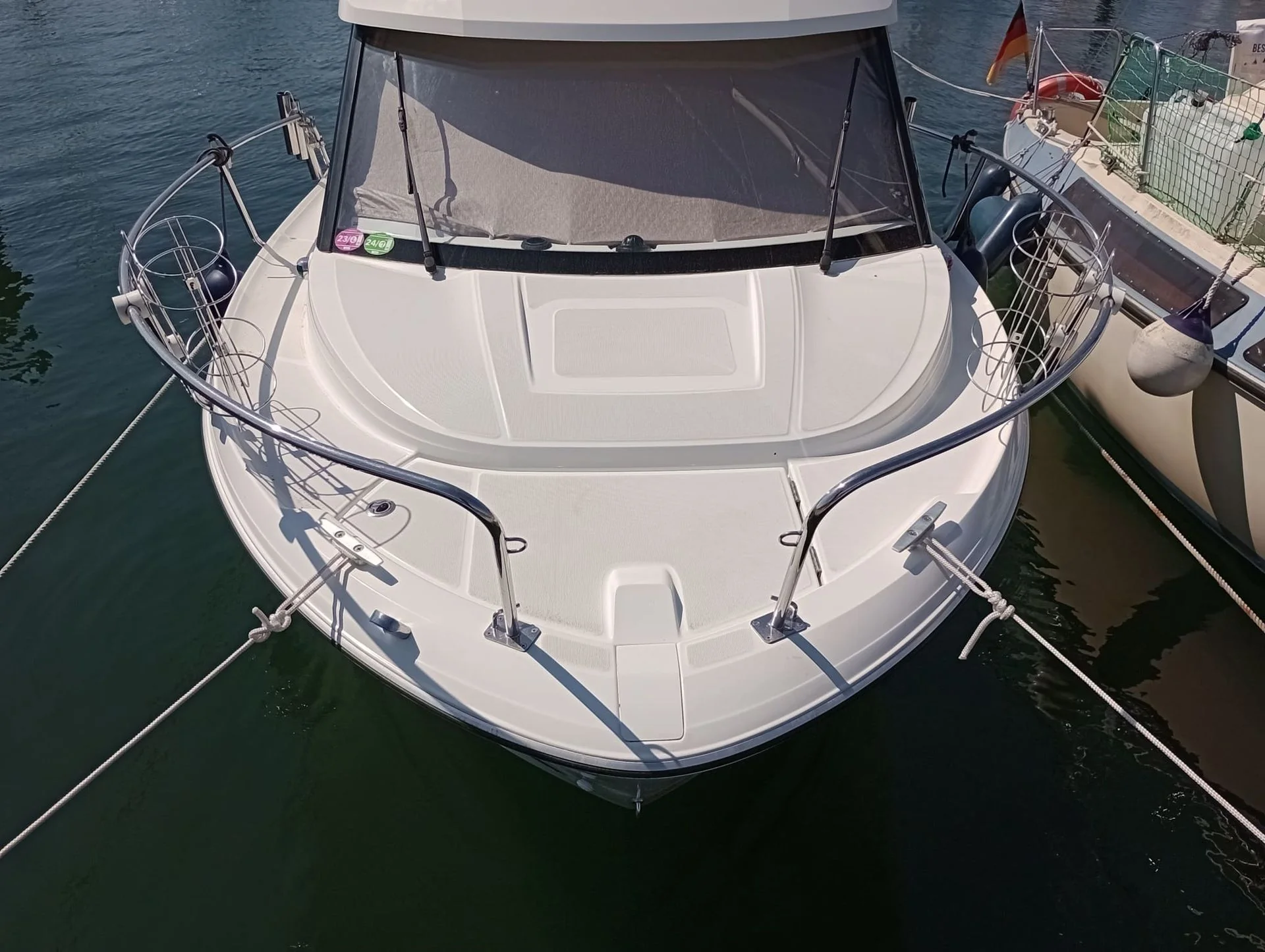 White fiberglass motorboat moored at dock in Jacksonville marine setting, viewed from above.