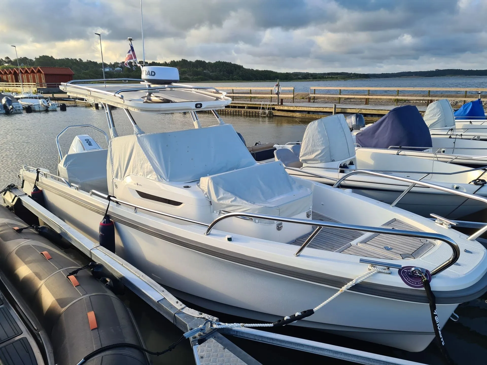 Moored fiberglass motorboats with canvas covers at Jacksonville marina, calm water and wooden docks visible.