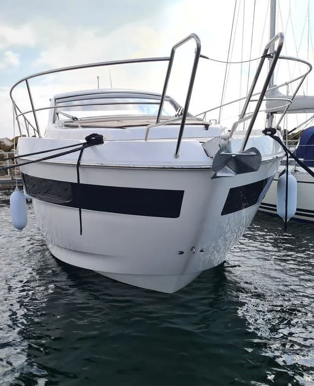White fiberglass motorboat moored in Jacksonville water with rigging and fenders visible.