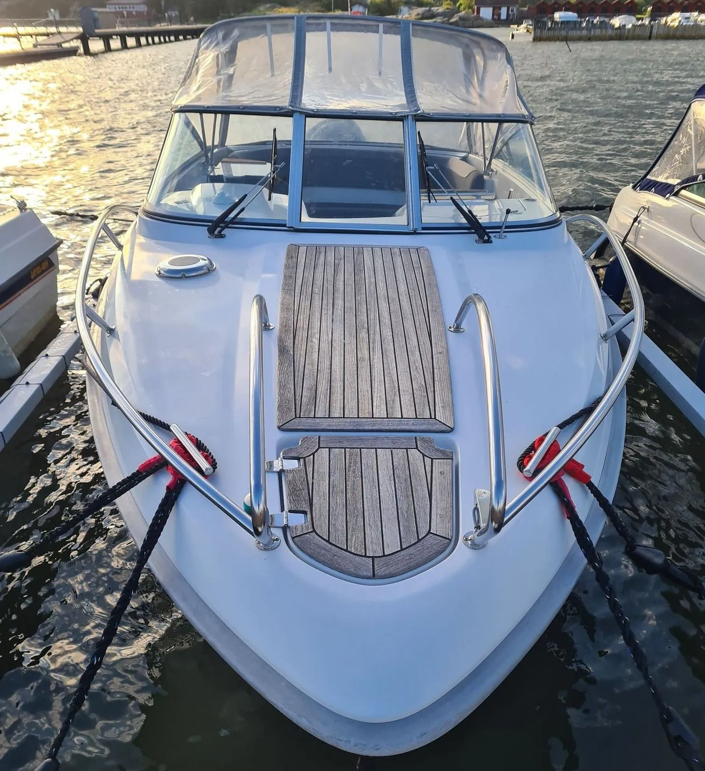 White fiberglass motorboat moored at Jacksonville waterfront marina in afternoon sunlight.