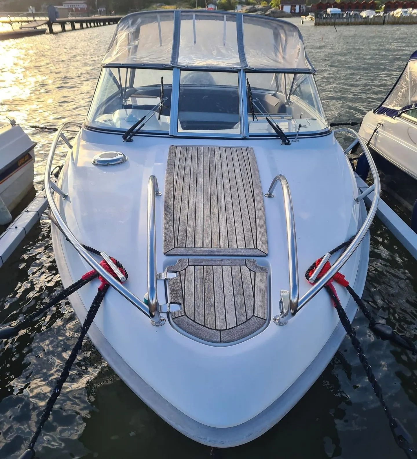White fiberglass motorboat moored at Jacksonville waterfront marina in afternoon sunlight.