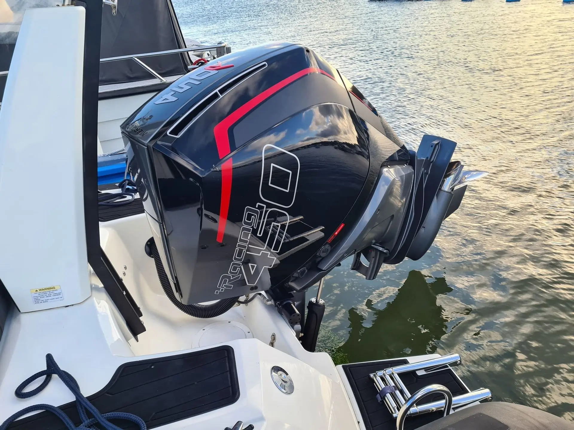 Outboard jet ski engine mounted on transom, dockside in Jacksonville waterway setting.