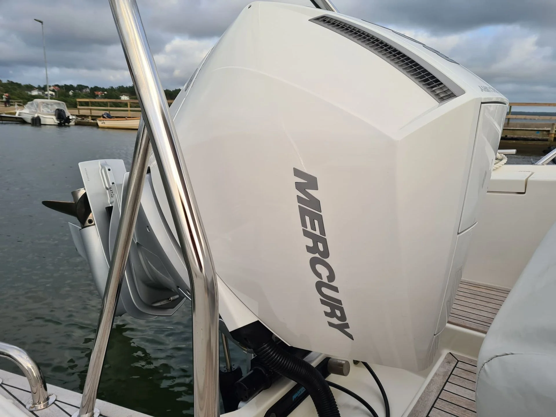 Outboard engine mounted on boat transom at Jacksonville marina with dockside boats visible.