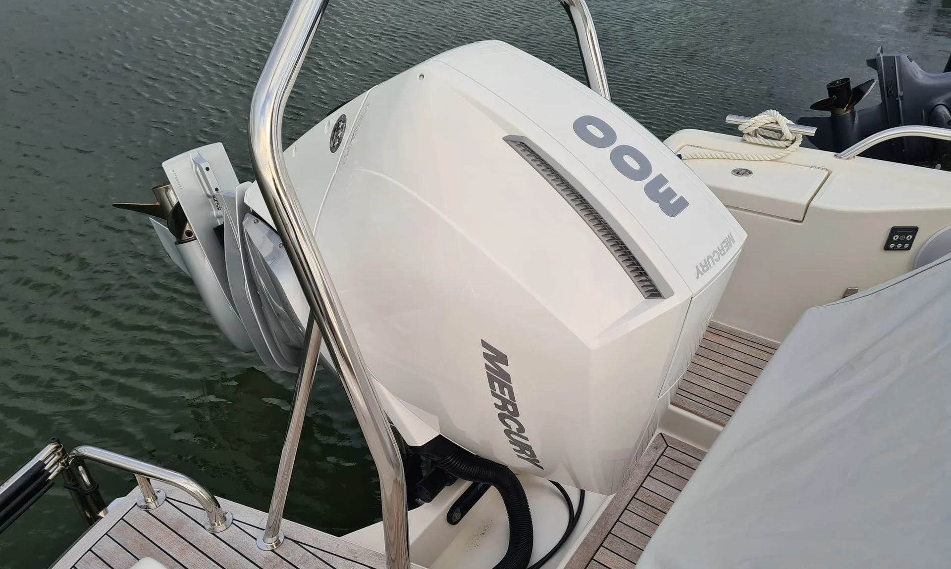 Outboard engine mounted on boat transom at Jacksonville waterside, showing white fiberglass hull and marine equipment.