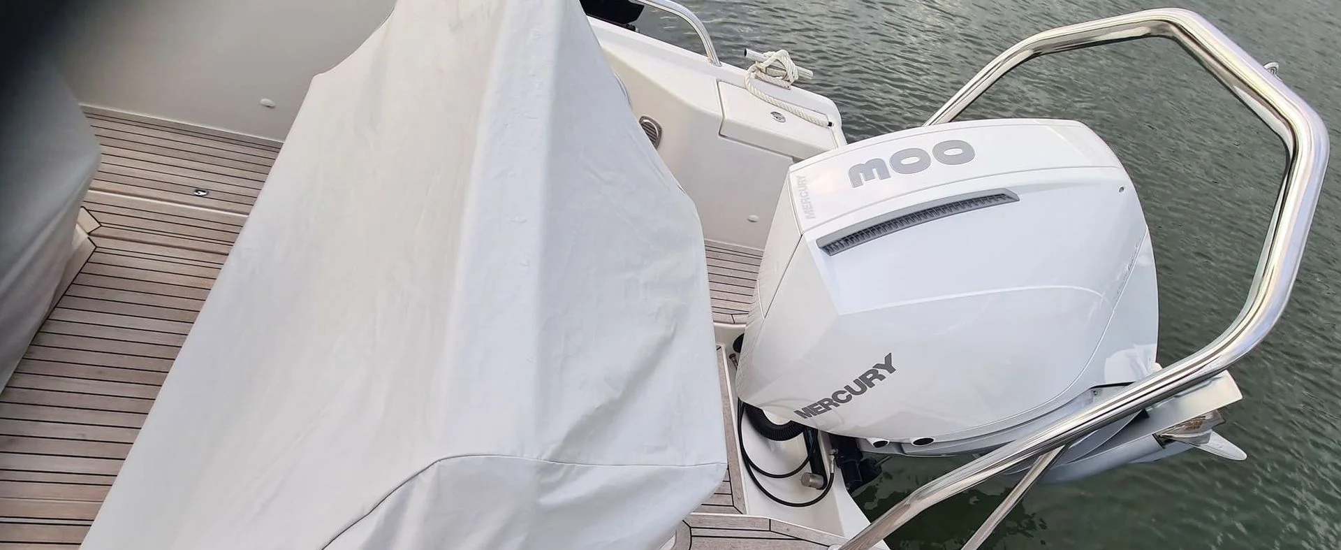 Mercury outboard engine mounted on boat transom at Jacksonville dock with mooring lines visible.