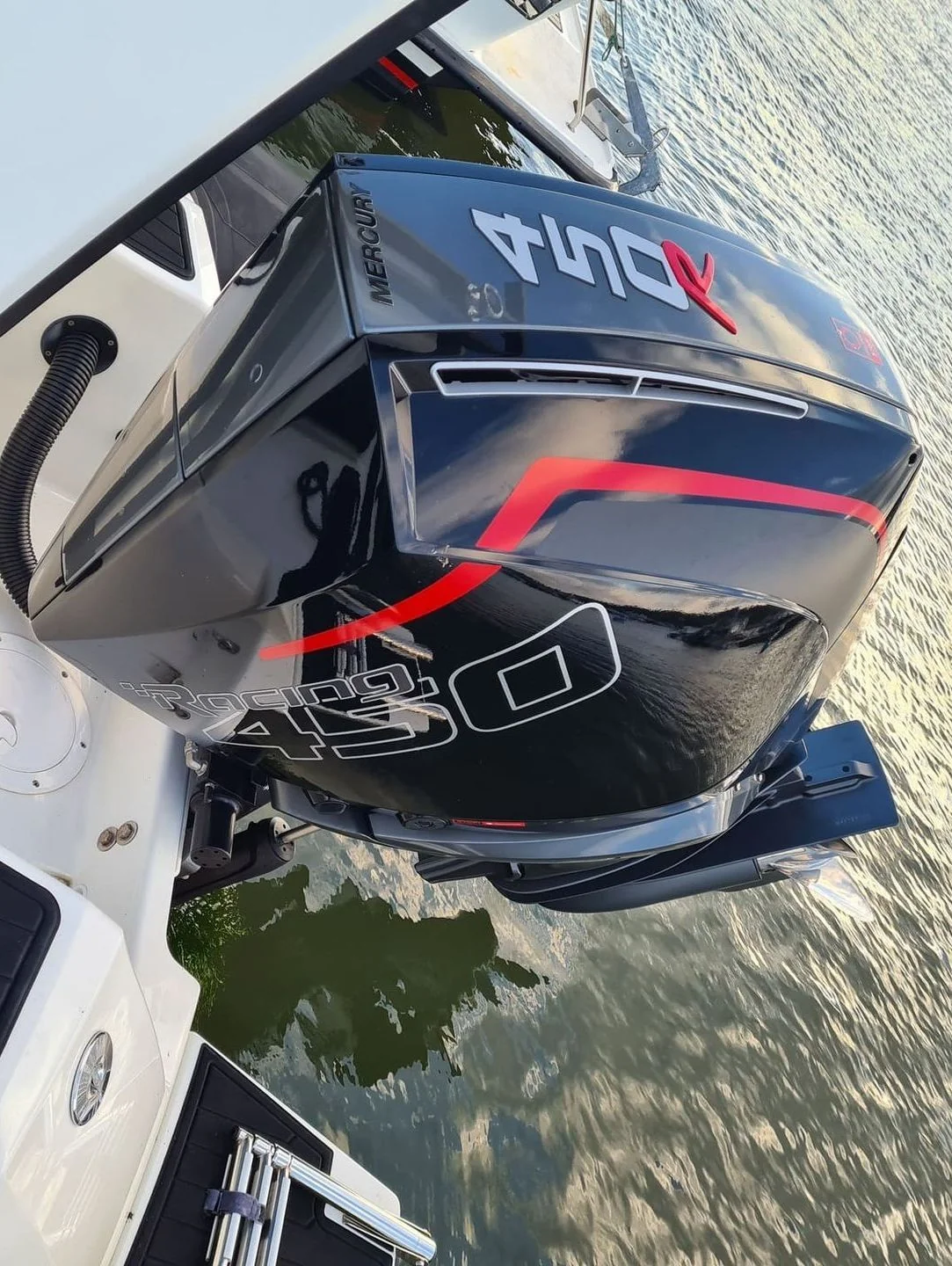 Mercury outboard engine with red accents mounted on boat transom at Jacksonville waterfront.