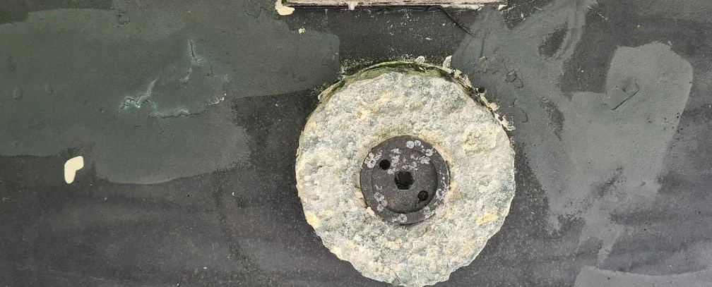 Corroded boat propeller with heavy marine growth and oxidation buildup.