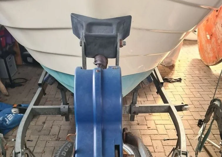Boat trailer winch and bow roller assembly viewed from above on brick driveway.